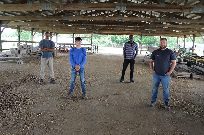 four men standing in a pavilion